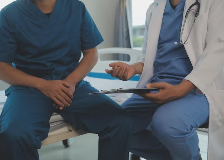 Doctor consulting with a patient during a medical examination and treatment planning discussion in a clinical setting.